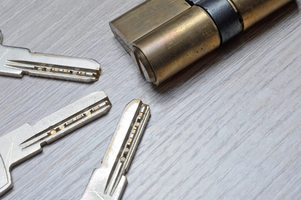 High-security dimple keys next to a lock cylinder