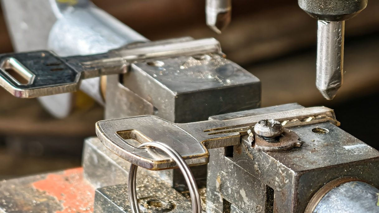 Key duplicating machine cutting a copy of a key