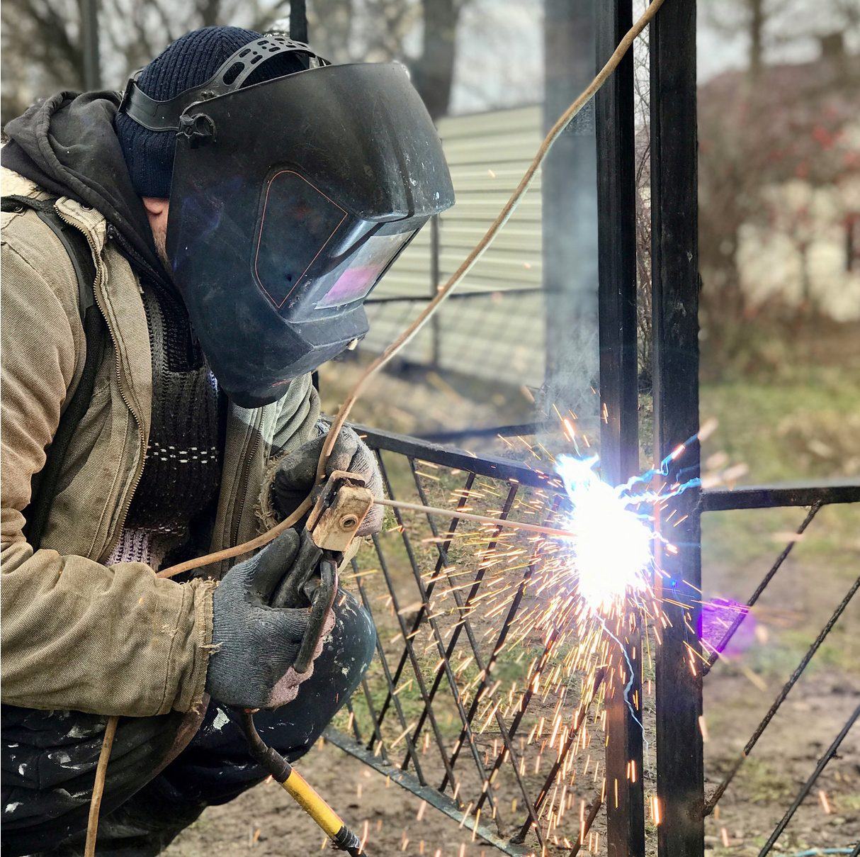Welder repairing a steel gate on site
