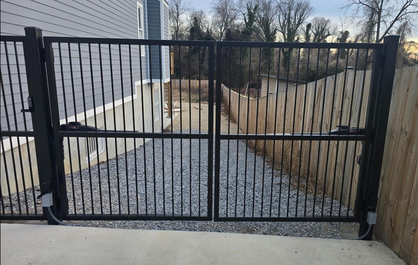 Custom double swing driveway gate and pedestrian gate fabricated and installed by RBD Security, with LiftMaster arm operators and a mechanical keypad lock