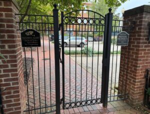 Black steel pedestrian gate between brick piers, designed, built and installed by RBD Security